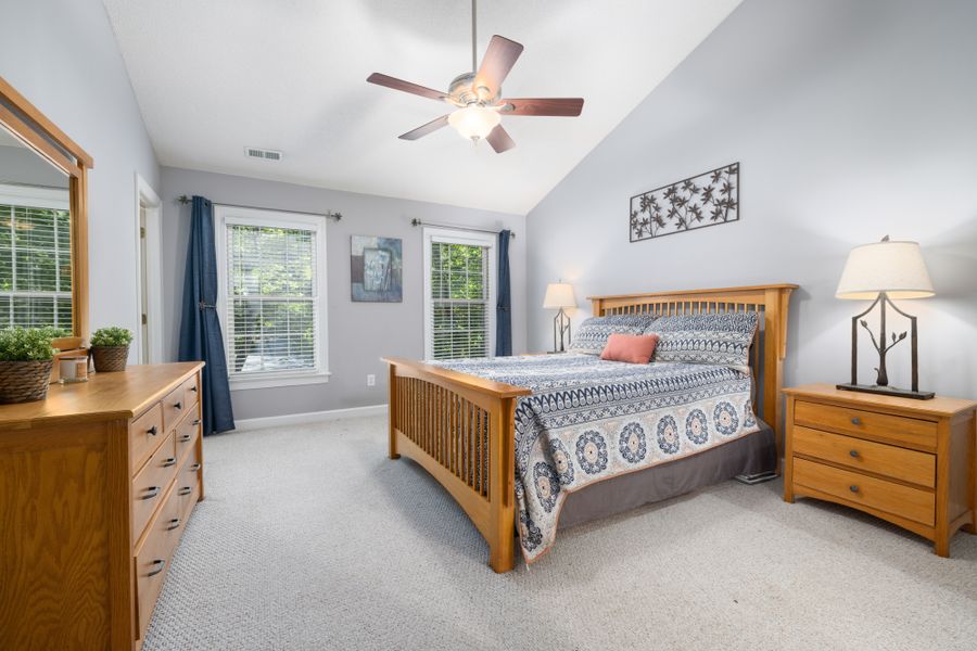 Solid wood double bed with a matching side table in a bright bedroom